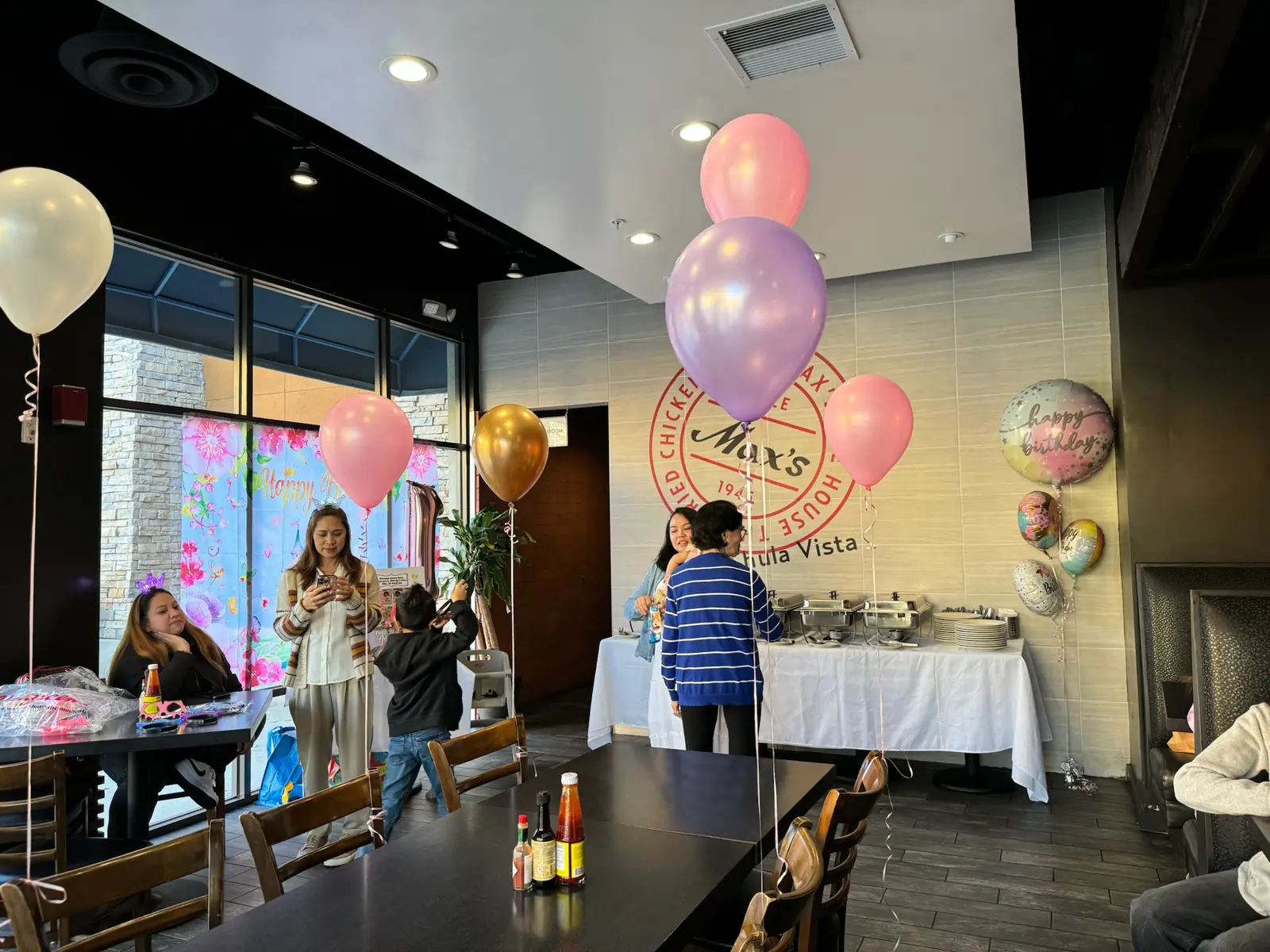 Pink, lavender and gold balloons and Happy Birthday foil balloons around the buffet beside the Max's Since 1945 wall sign at Max's Chula Vista